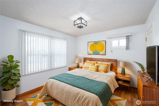 bedroom featuring baseboards and wood finished floors