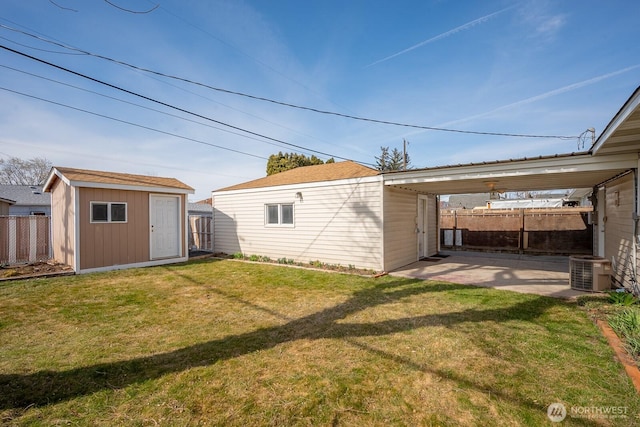 exterior space featuring fence, central AC unit, a yard, an outdoor structure, and a carport