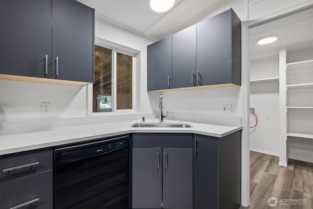 kitchen featuring light countertops, black dishwasher, wood finished floors, and a sink