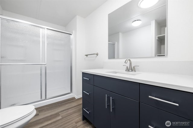 full bathroom with vanity, wood finished floors, and a stall shower