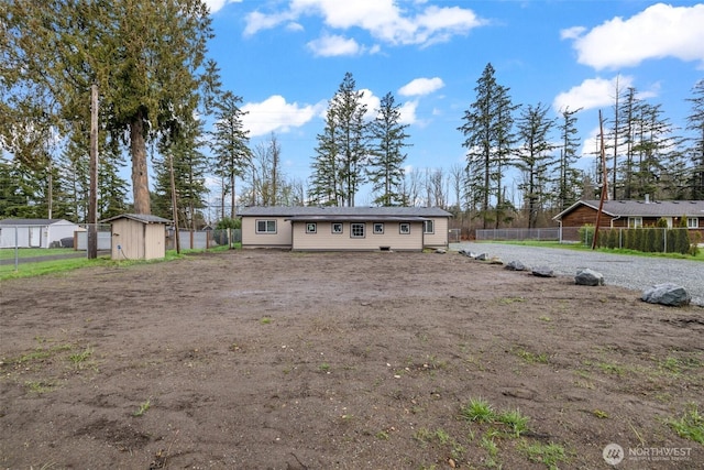 view of front of property featuring an outbuilding, a storage shed, and fence