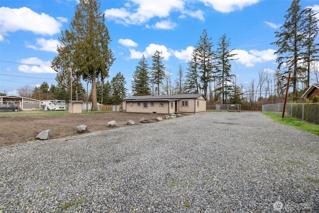 exterior space featuring gravel driveway and fence