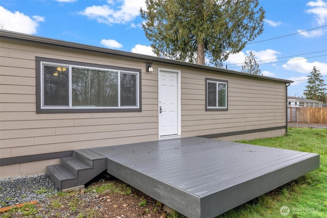 rear view of house featuring a deck and fence