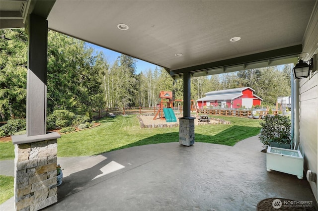 view of patio / terrace featuring a playground and fence
