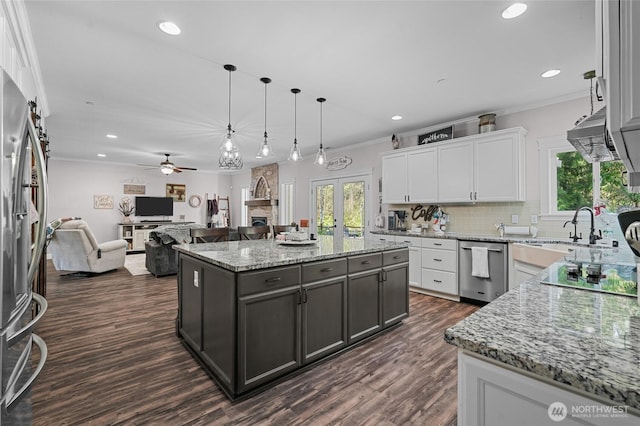 kitchen featuring a healthy amount of sunlight, appliances with stainless steel finishes, ceiling fan, and white cabinets