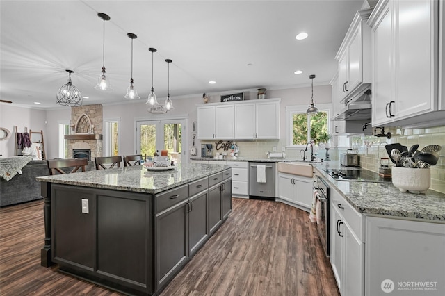 kitchen with a sink, appliances with stainless steel finishes, crown molding, and white cabinetry