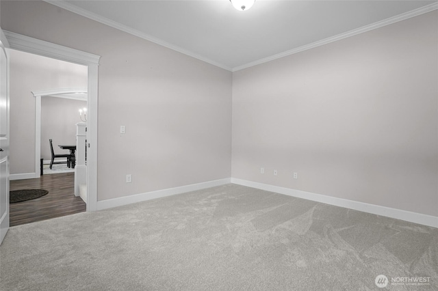 spare room featuring crown molding, baseboards, and carpet