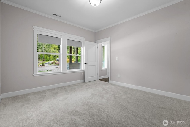 unfurnished room with carpet floors, baseboards, visible vents, and ornamental molding