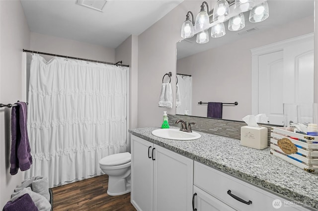 full bathroom featuring decorative backsplash, visible vents, wood finished floors, vanity, and toilet