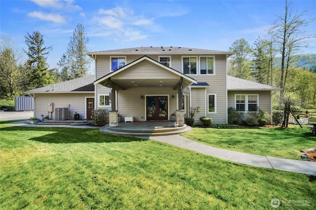 traditional-style house with central AC, french doors, a shingled roof, and a front lawn