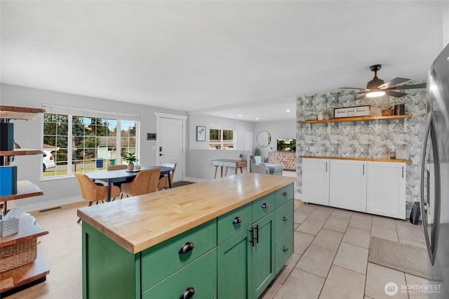 kitchen featuring visible vents, ceiling fan, butcher block countertops, freestanding refrigerator, and green cabinetry