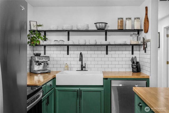 kitchen featuring butcher block countertops, appliances with stainless steel finishes, green cabinets, and open shelves