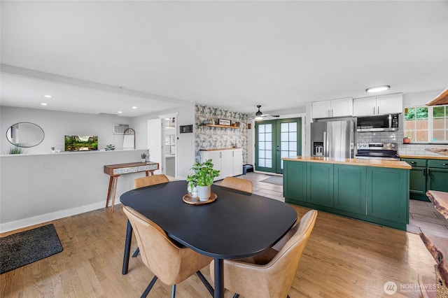 dining area featuring a wealth of natural light, french doors, light wood-type flooring, and baseboards