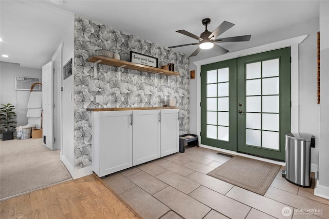 interior space featuring a wall unit AC, visible vents, open shelves, white cabinets, and french doors