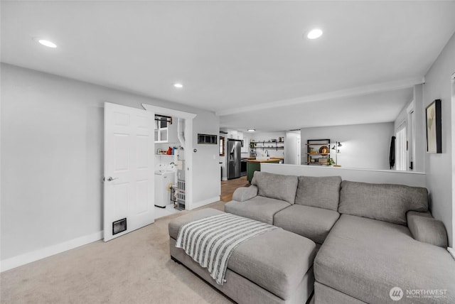 living room featuring visible vents, baseboards, washer / dryer, recessed lighting, and light carpet