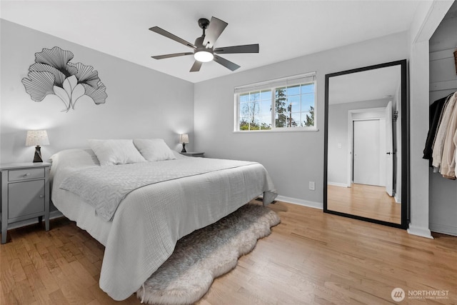 bedroom with a ceiling fan, light wood-type flooring, and baseboards