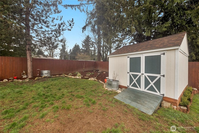 view of yard featuring an outdoor structure, a fenced backyard, and a shed