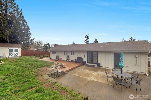 back of house with an outbuilding, fence, a yard, french doors, and a storage shed