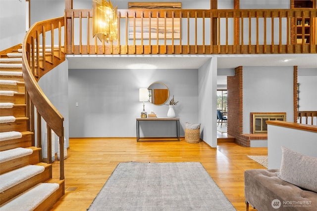 stairway featuring a brick fireplace and wood finished floors