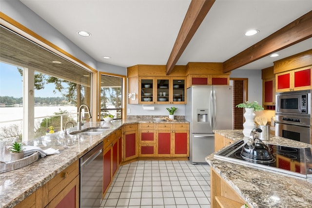 kitchen with beam ceiling, light tile patterned flooring, a sink, glass insert cabinets, and appliances with stainless steel finishes