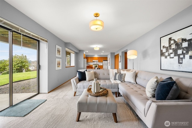 living area featuring light colored carpet and baseboards