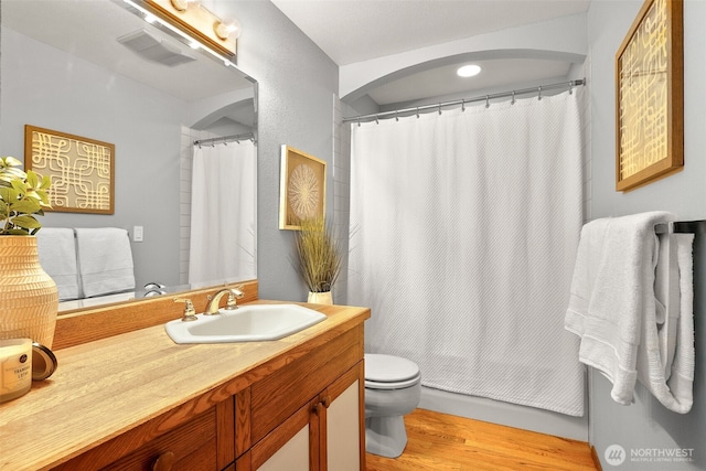 bathroom with vanity, wood finished floors, visible vents, curtained shower, and toilet