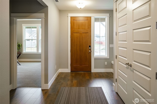 foyer with baseboards, plenty of natural light, visible vents, and dark wood-style floors