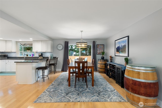 dining room with recessed lighting, light wood-style flooring, and baseboards