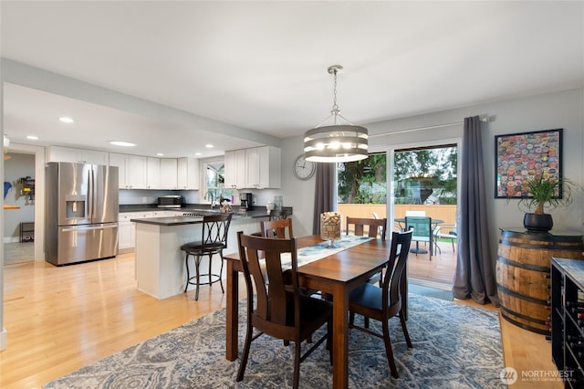 dining area with a notable chandelier, recessed lighting, and light wood finished floors