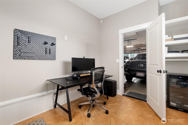 office space featuring wine cooler and finished concrete flooring