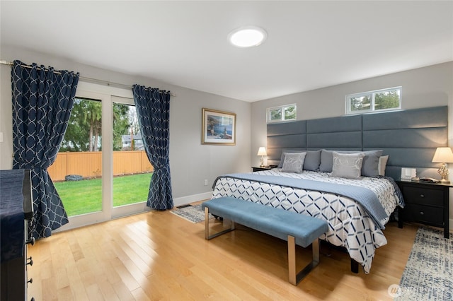 bedroom featuring baseboards, wood finished floors, and access to exterior