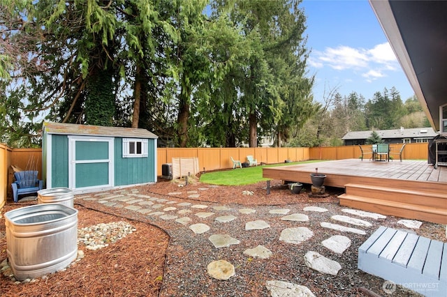 view of yard with central air condition unit, an outbuilding, a fenced backyard, a storage shed, and a wooden deck