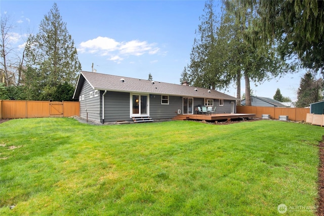 rear view of property with a lawn, a deck, a gate, entry steps, and a fenced backyard