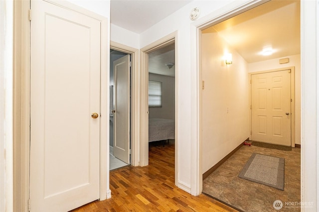 hallway featuring wood finished floors and baseboards