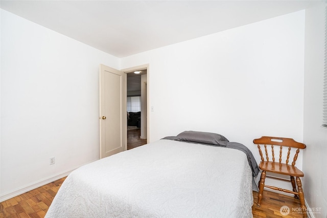 bedroom with baseboards and wood finished floors