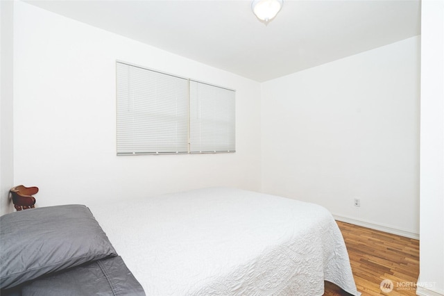 bedroom featuring baseboards and wood finished floors