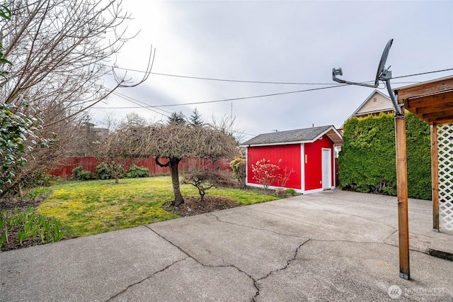 view of patio / terrace with a storage unit, an outbuilding, and fence