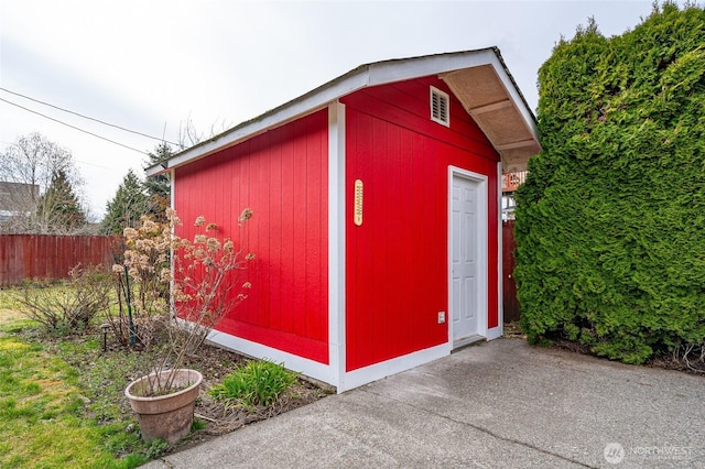 view of outdoor structure featuring an outbuilding and fence