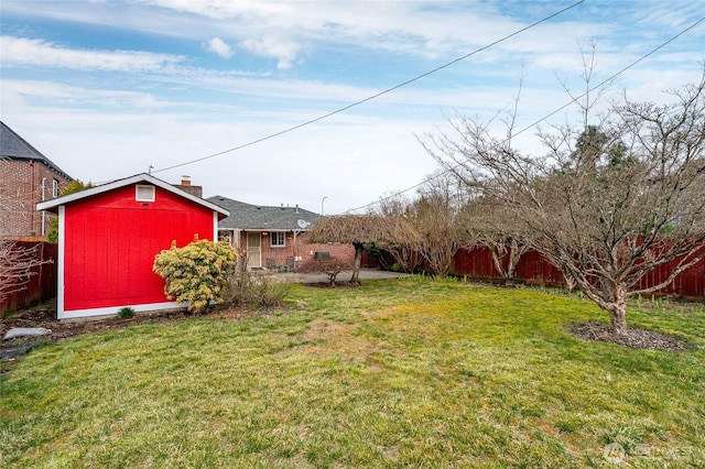 view of yard with a patio area, fence, and an outbuilding