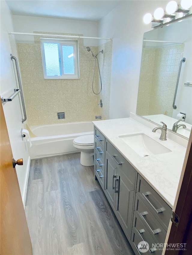 bathroom featuring shower / bathing tub combination, toilet, wood finished floors, and vanity