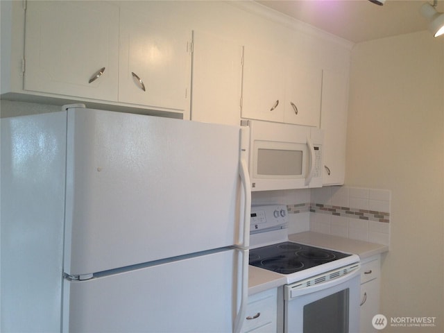 kitchen with white appliances, tasteful backsplash, and white cabinets