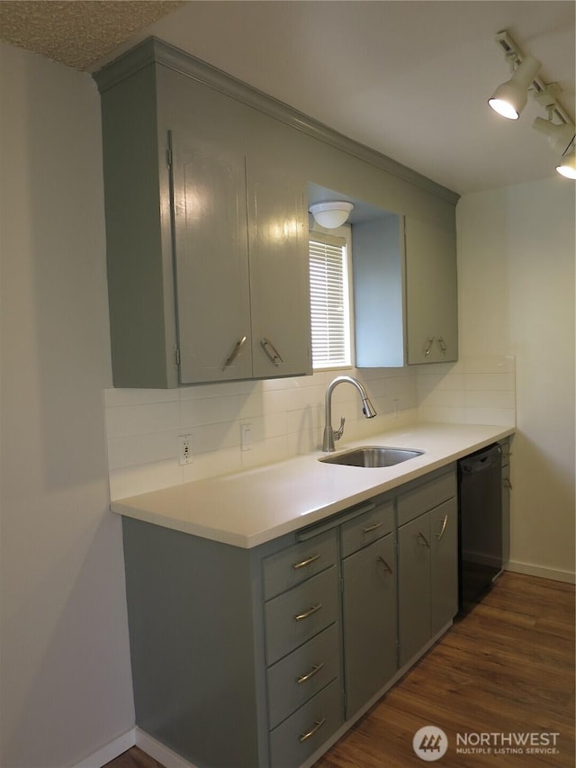 kitchen featuring gray cabinets, a sink, backsplash, dishwasher, and dark wood-style flooring