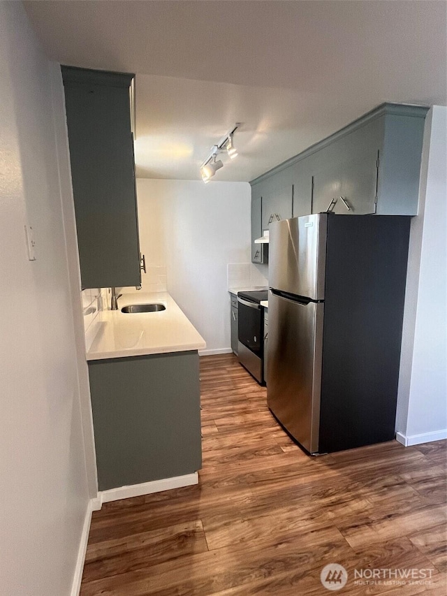 kitchen with a sink, electric range, wood finished floors, and freestanding refrigerator