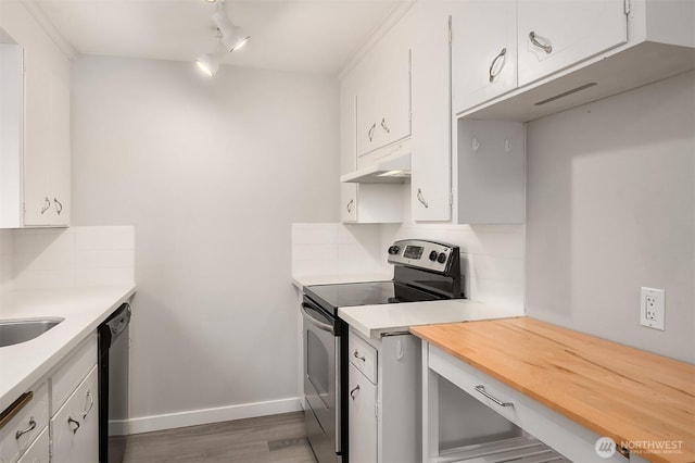 kitchen with appliances with stainless steel finishes, under cabinet range hood, decorative backsplash, and dark wood-type flooring