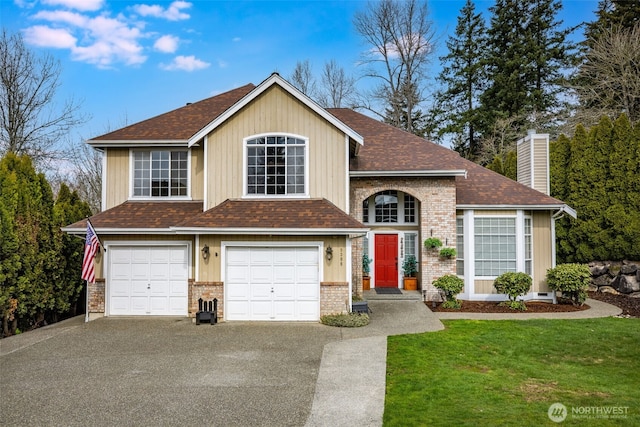 traditional-style house featuring a front yard, driveway, an attached garage, a chimney, and brick siding