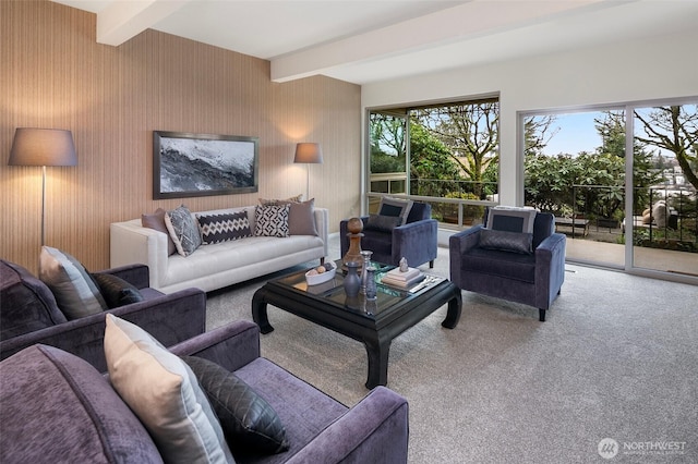 carpeted living area featuring beamed ceiling and plenty of natural light