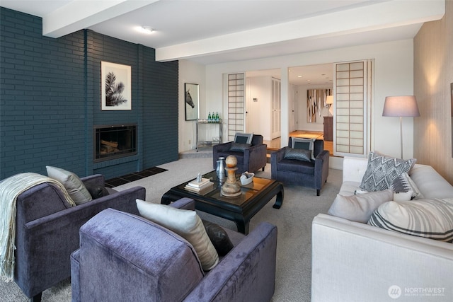 carpeted living area with beam ceiling and a large fireplace