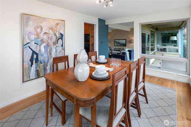 dining space with baseboards and light wood finished floors