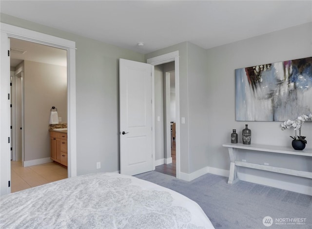 carpeted bedroom featuring baseboards and ensuite bathroom