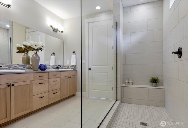 full bathroom with tile patterned flooring, double vanity, and decorative backsplash